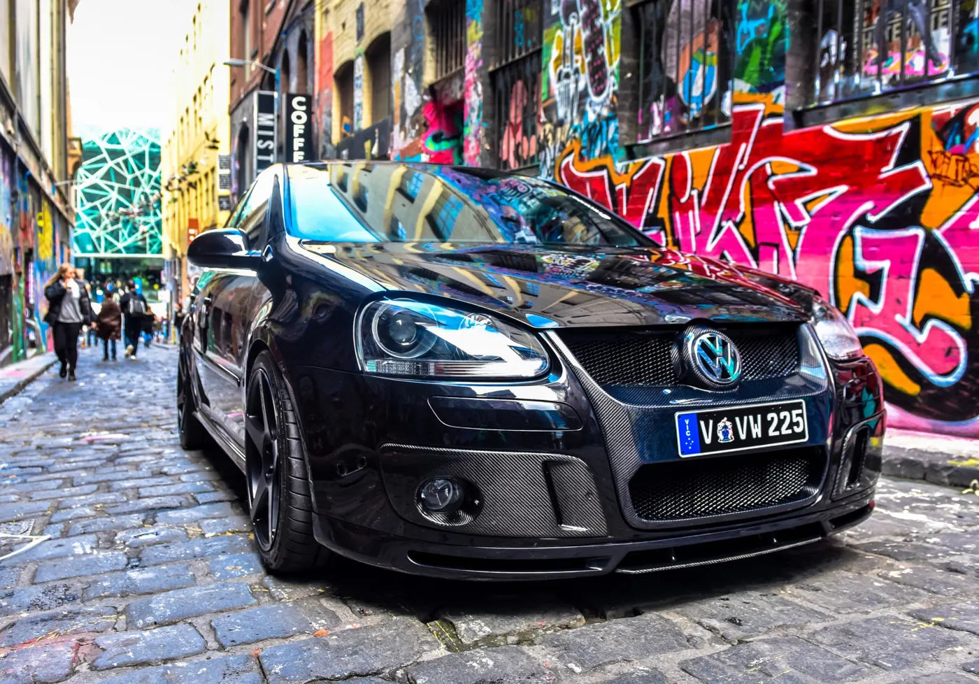 Black VW Central MK5 GTI Pirelli parked in a graffiti-lined laneway